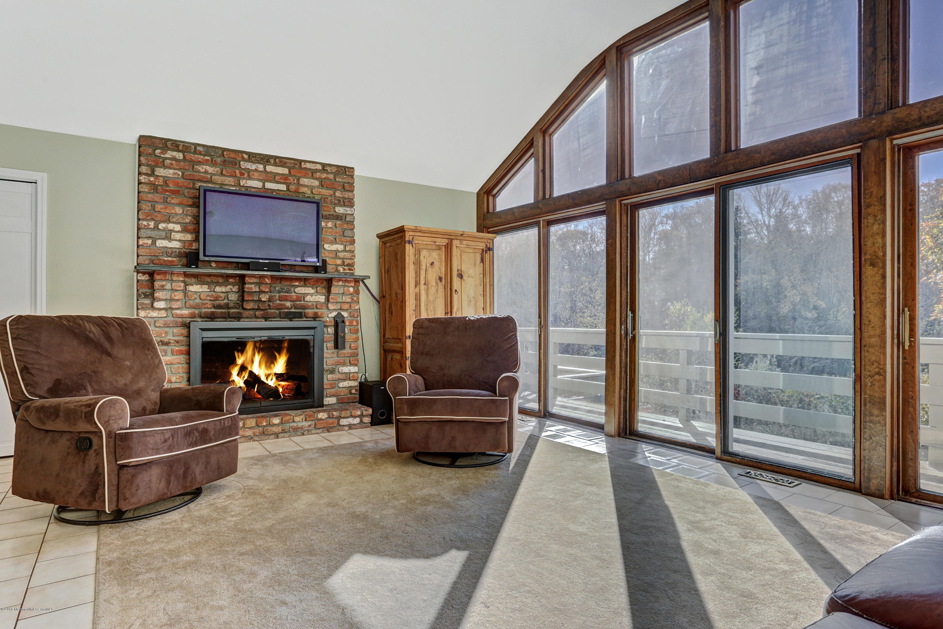 254 Newman Springs Road Colts Neck, NJ 07722 - Photo 11 of 30 a living room with furniture a flat screen tv and a fireplace