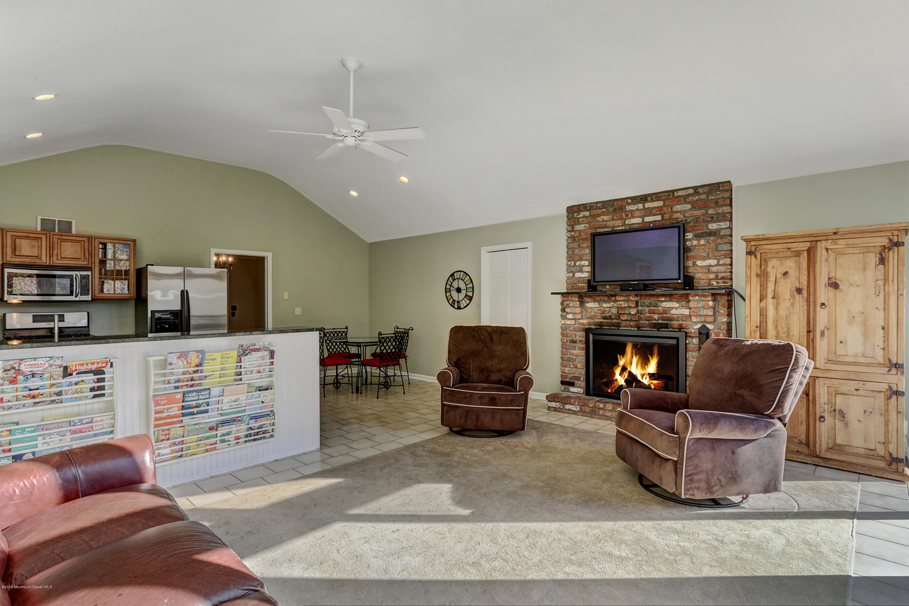 254 Newman Springs Road Colts Neck, NJ 07722 - Photo 13 of 30 a living room with furniture a fireplace a flat screen tv and kitchen view