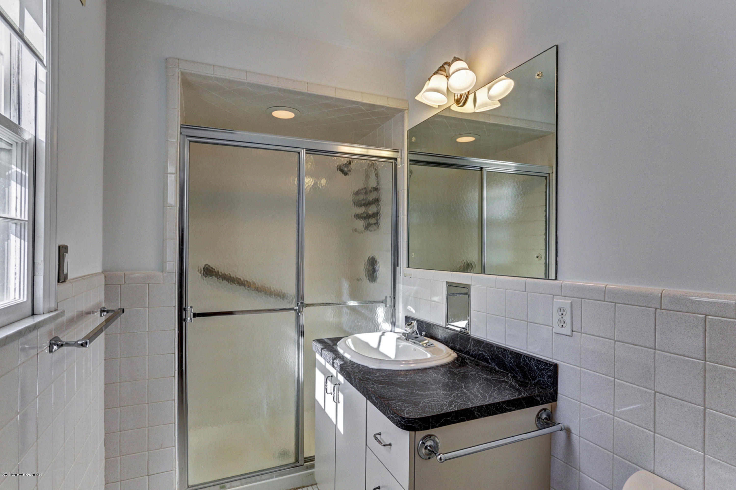 254 Newman Springs Road Colts Neck, NJ 07722 - Photo 16 of 30 a bathroom with a granite countertop shower a sink and a mirror