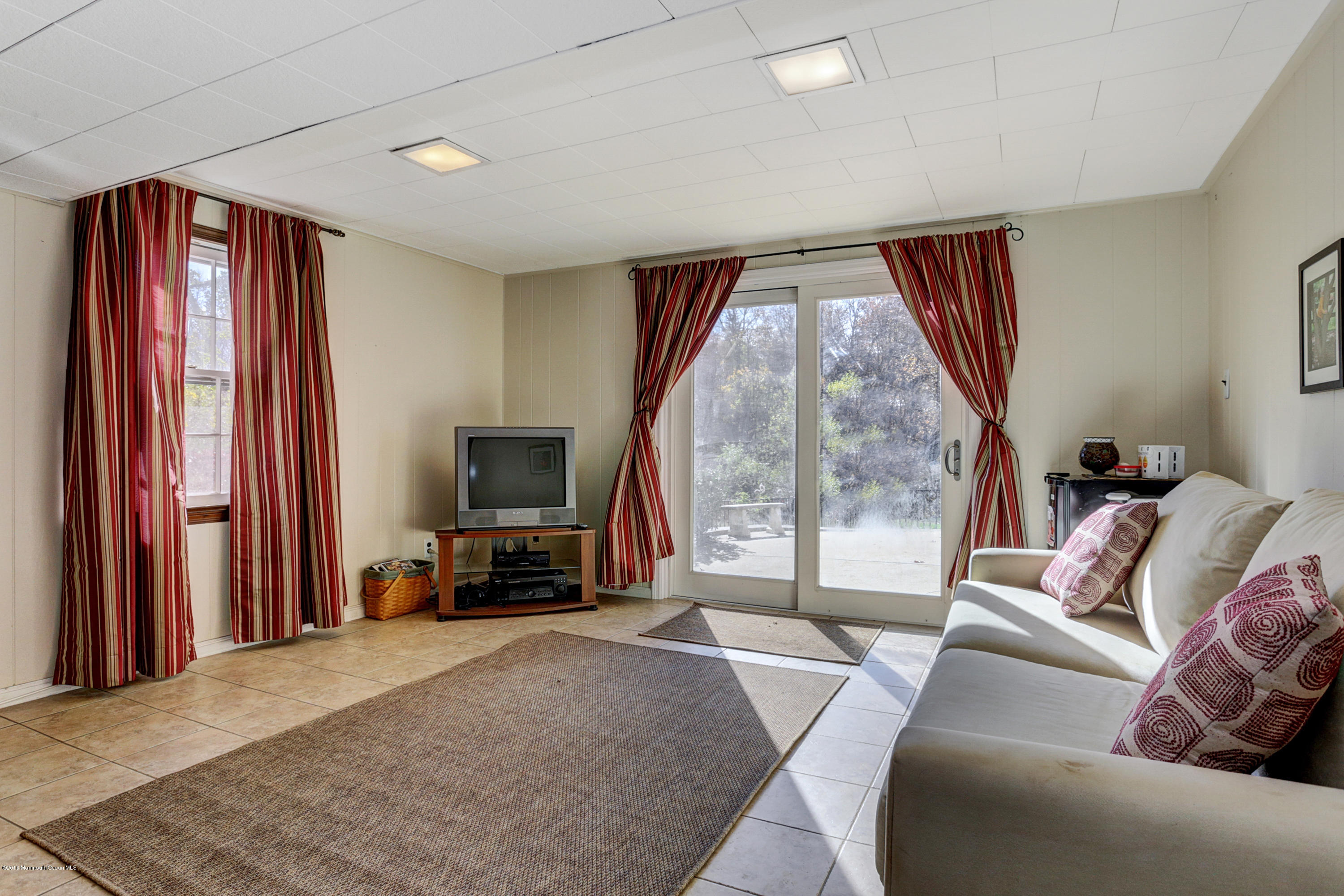 254 Newman Springs Road Colts Neck, NJ 07722 - Photo 23 of 30 a living room with furniture a large window and a flat screen tv
