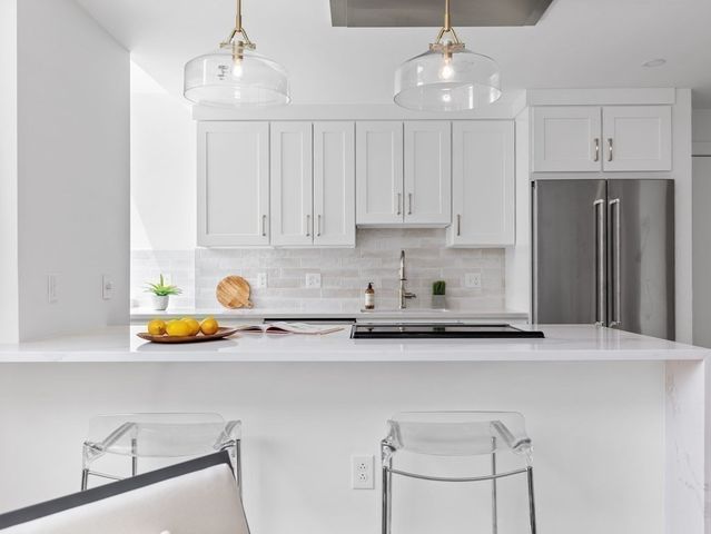 a kitchen with stainless steel appliances granite countertop a sink refrigerator and microwave