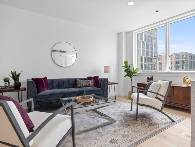 a living room with furniture a rug and a large window