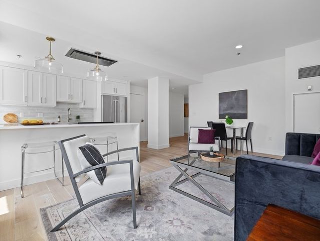 a living room with furniture and kitchen view