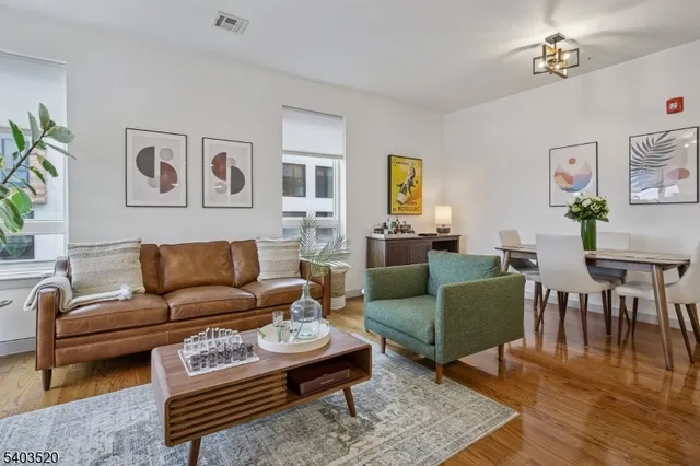 a living room with furniture a couch and paintings on the wall