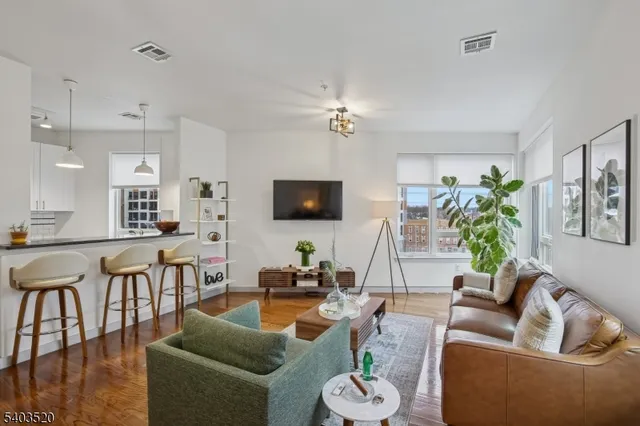 a kitchen with stainless steel appliances granite countertop a sink a stove and chairs