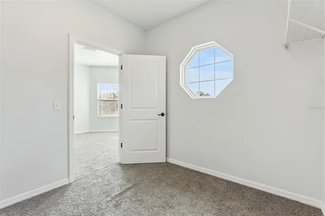 an empty room with cabinet and mirror