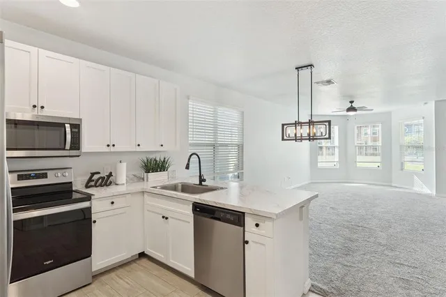 a kitchen with a sink stove and microwave