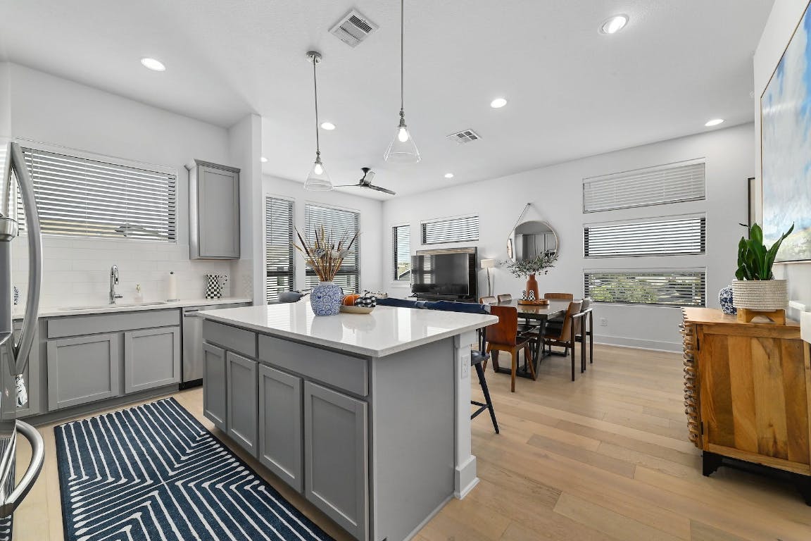Kitchen with gray cabinetry, plenty of natural light, decorative backsplash, light wood-style flooring, and recessed lighting