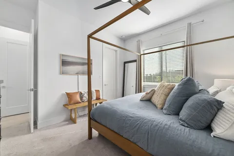 a bedroom with a bed and a lamp next to a window