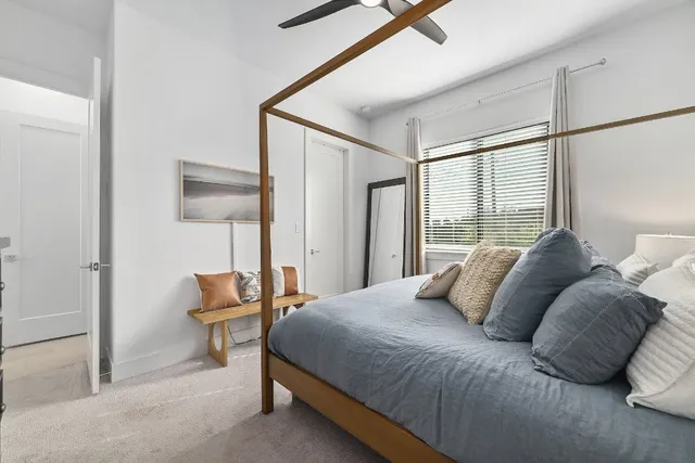 a bedroom with a bed and a lamp next to a window