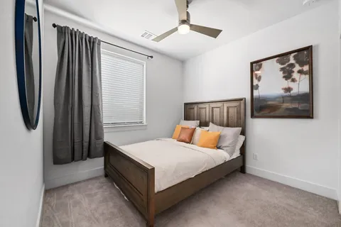 a bedroom with a bed and painting on the wall