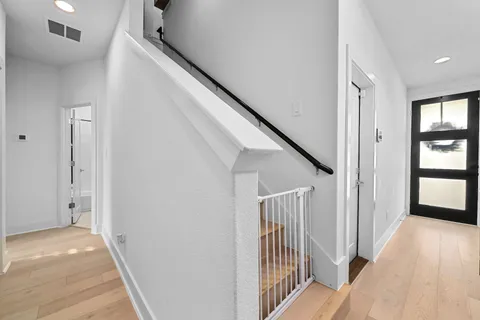 a view of a hallway with wooden floor and entryway