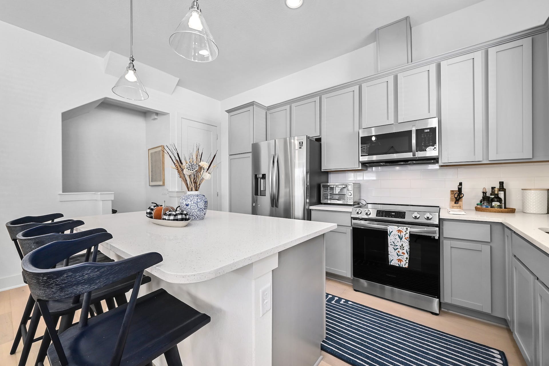 2050 Lohmans Spur Road, Unit 2301 Lakeway, TX 78734 - Photo 7 of 27 a kitchen with stainless steel appliances granite countertop a stove a refrigerator a sink dishwasher a dining table and chairs with wooden floor