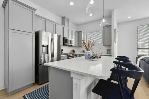 a kitchen with refrigerator a sink and a stove