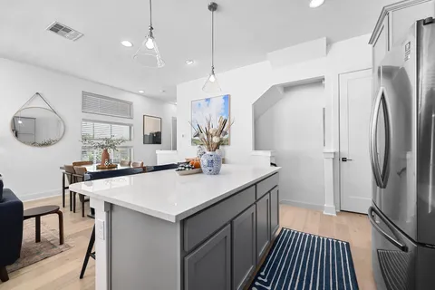 a kitchen with kitchen island a sink stove and refrigerator