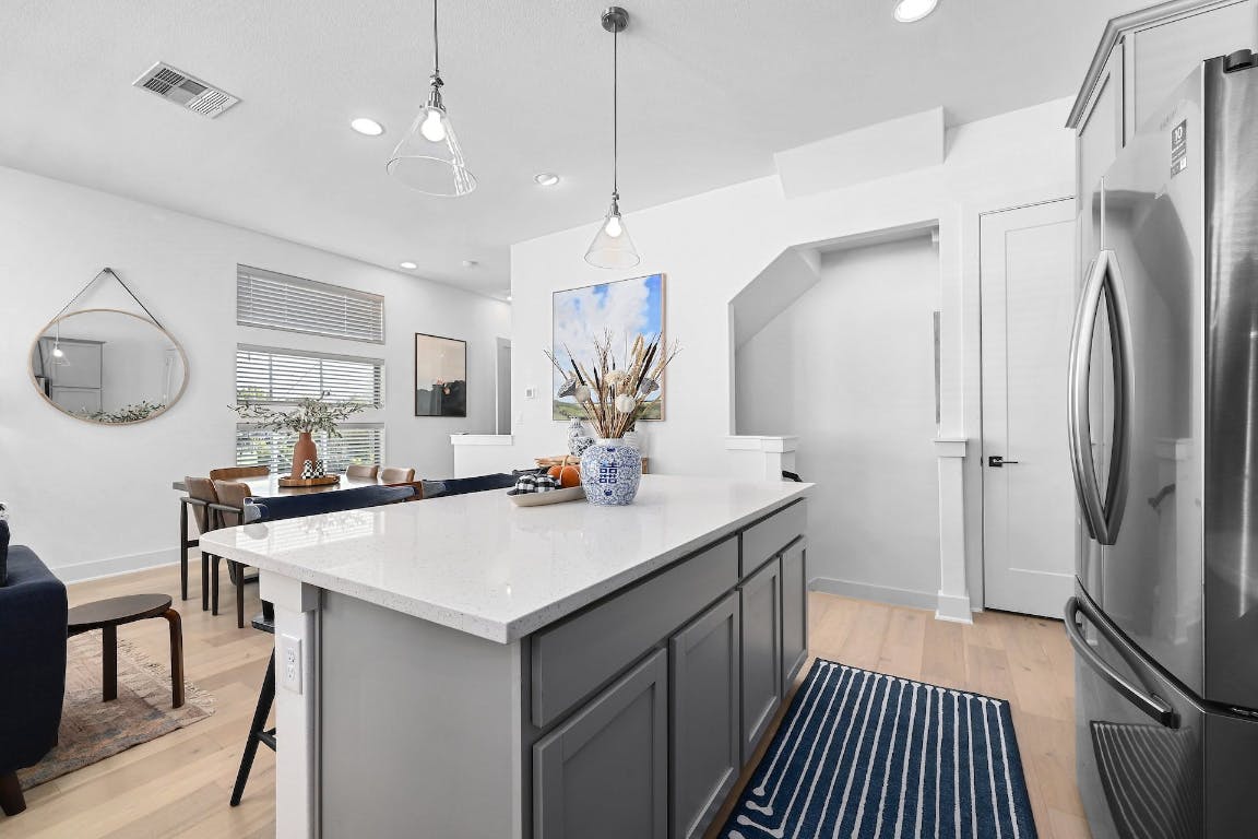 2050 Lohmans Spur Road, Unit 2301 Lakeway, TX 78734 - Photo 9 of 27 Kitchen featuring freestanding refrigerator, light stone countertops, hanging light fixtures, light wood-style floors, and recessed lighting