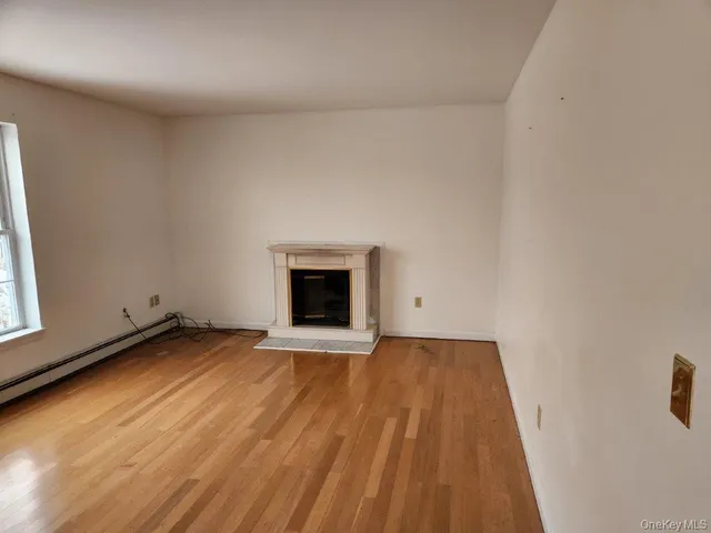 a view of an empty room with a fireplace and a window