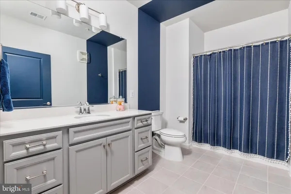 a bathroom with a double vanity sink toilet and a mirror