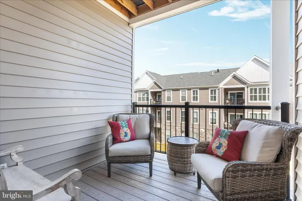 a roof deck with couch and chairs