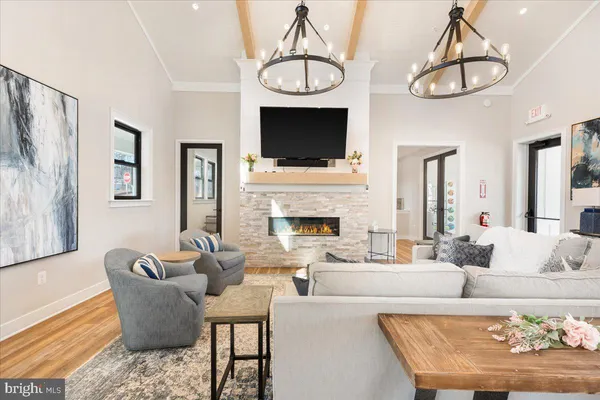 a dining room with wooden floor a chandelier a wooden table and chairs