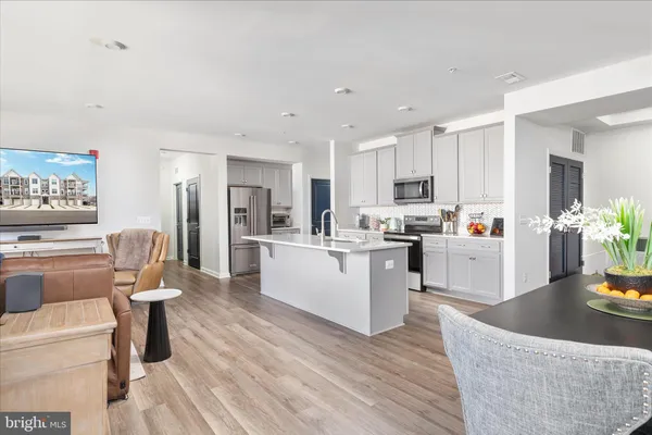a living room with furniture and a dining table with kitchen view