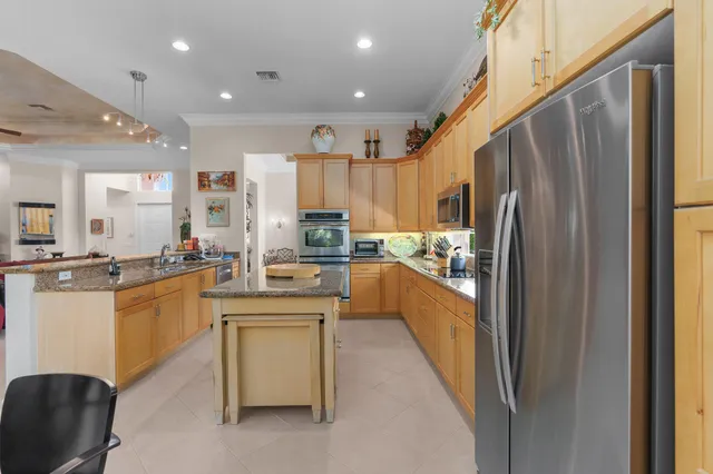a kitchen with stainless steel appliances a refrigerator a sink dishwasher a stove and white cabinets with wooden floor