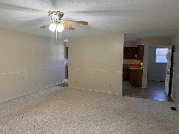 an empty room with fireplace and fan