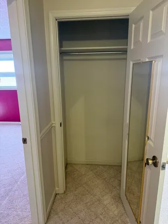 an empty room with windows and a chandelier fan
