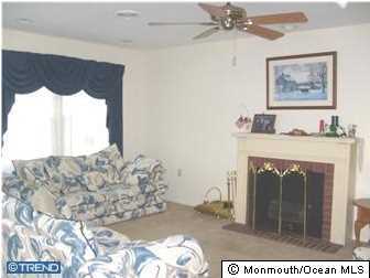 133B Sunset Road, Unit B Whiting, NJ 08759 - Photo 4 of 8 a bed sitting in a bedroom next to a window with a chandelier