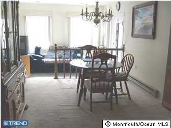 133B Sunset Road, Unit B Whiting, NJ 08759 - Photo 5 of 8 a dining room with furniture a rug and a chandelier