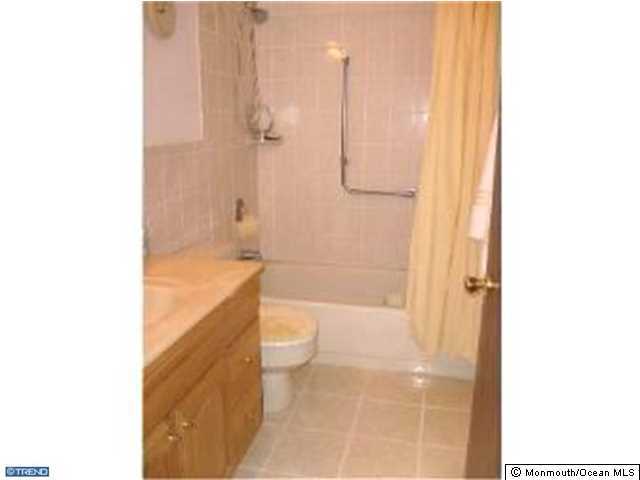 133B Sunset Road, Unit B Whiting, NJ 08759 - Photo 8 of 8 a bathroom with a granite countertop bathtub shower sink vanity and toilet