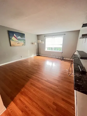 a view of a livingroom with wooden floor and window