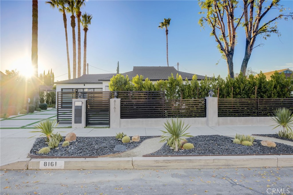 8161 Encino Avenue Northridge, CA 91325 - Photo 19 of 72 a front view of a house with a yard and potted plants