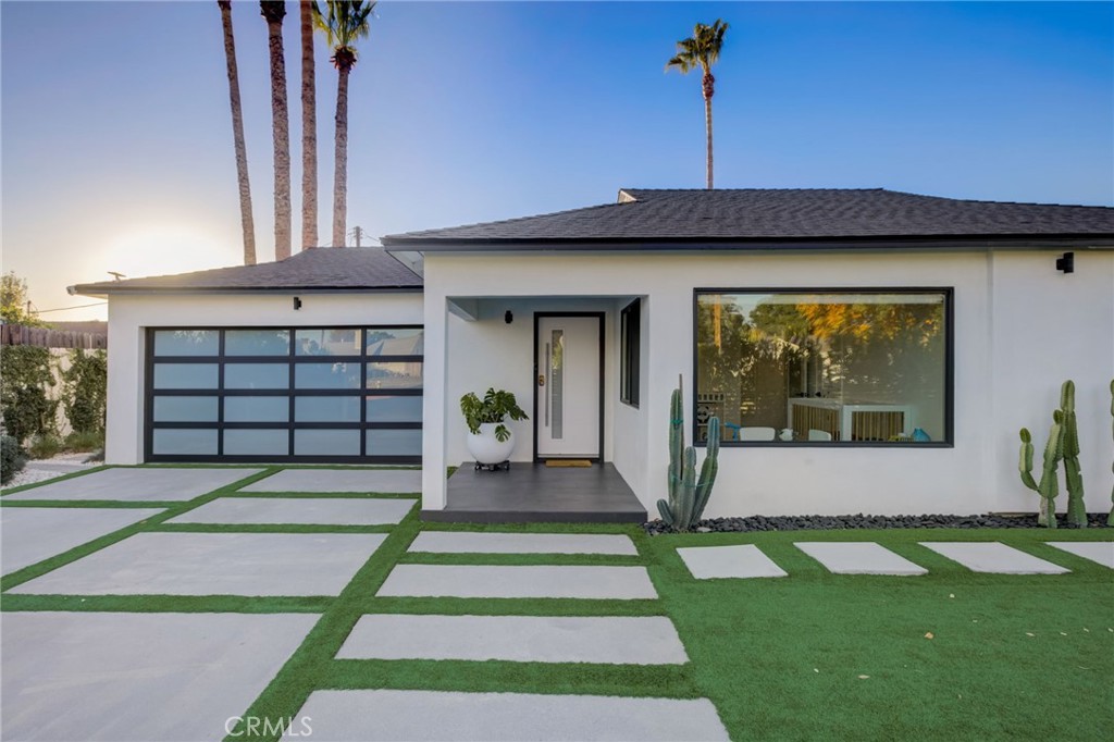 8161 Encino Avenue Northridge, CA 91325 - Photo 24 of 72 a front view of a house with a yard and garage