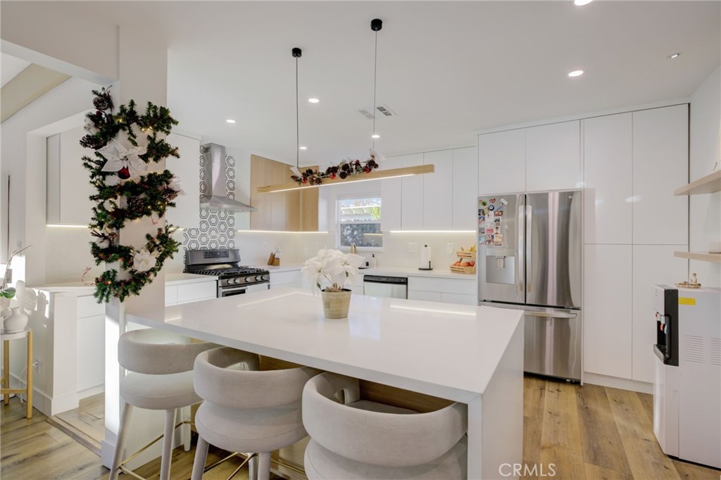 8161 Encino Avenue Northridge, CA 91325 - Photo 35 of 72 a kitchen with granite countertop a table chairs stove and refrigerator