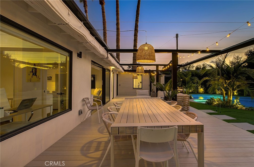 8161 Encino Avenue Northridge, CA 91325 - Photo 10 of 72 a view of a patio with table and chairs potted plants with wooden floor and fence