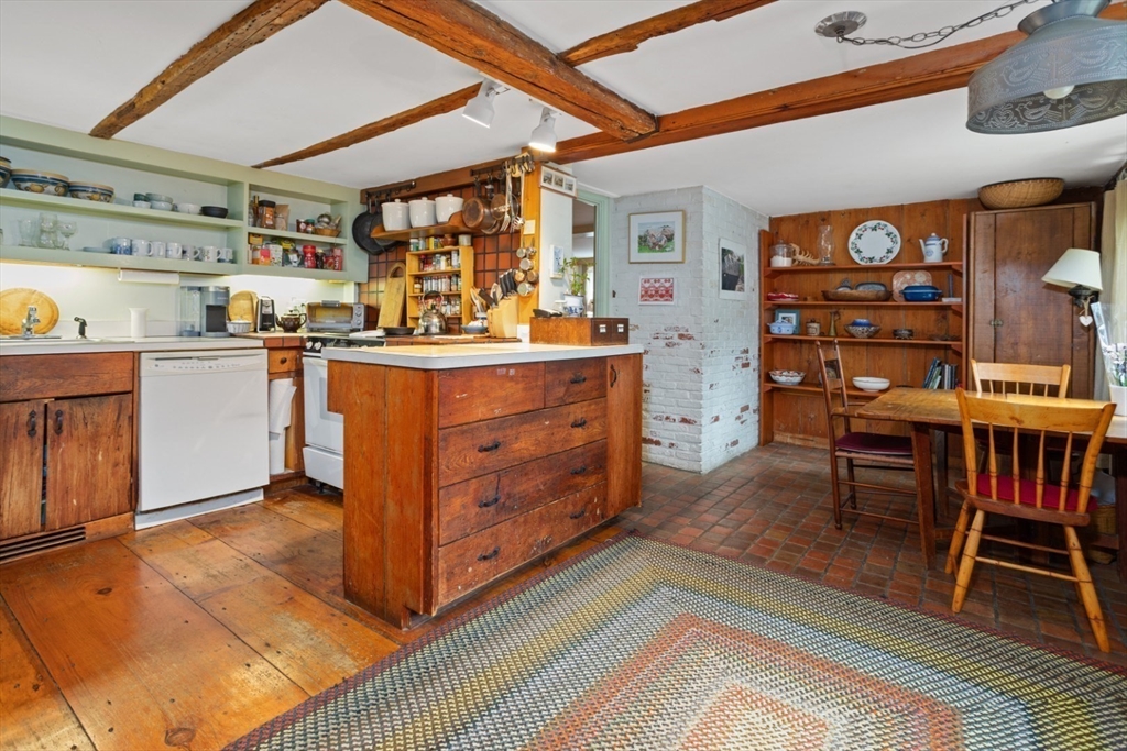 16 Pine Street Gloucester, MA 01930 - Photo 9 of 42 a kitchen with stainless steel appliances granite countertop a table chairs and a wooden floor