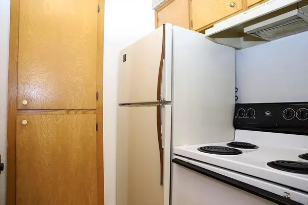 a kitchen with a refrigerator and white cabinets