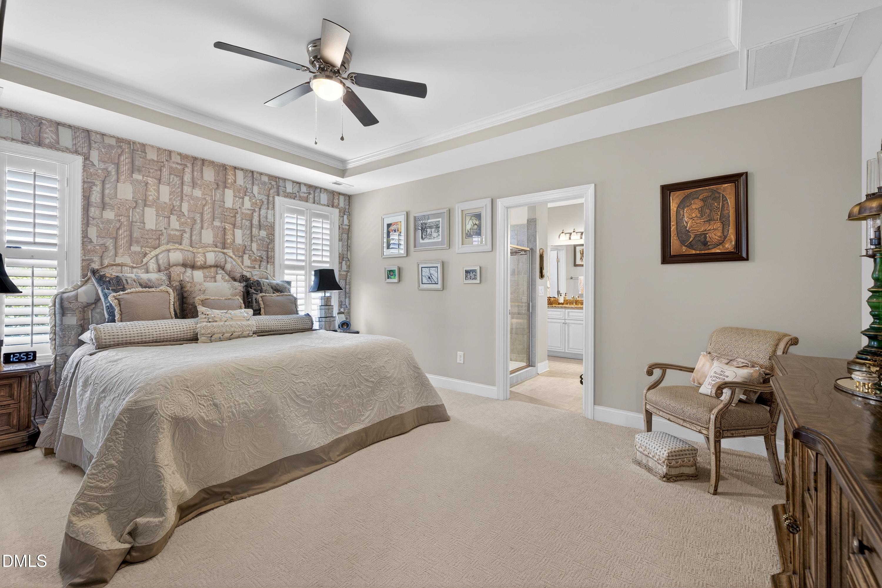 121 Telluride Trail Garner, NC 27529 - Photo 10 of 41 a spacious bedroom with a bed and a chandelier