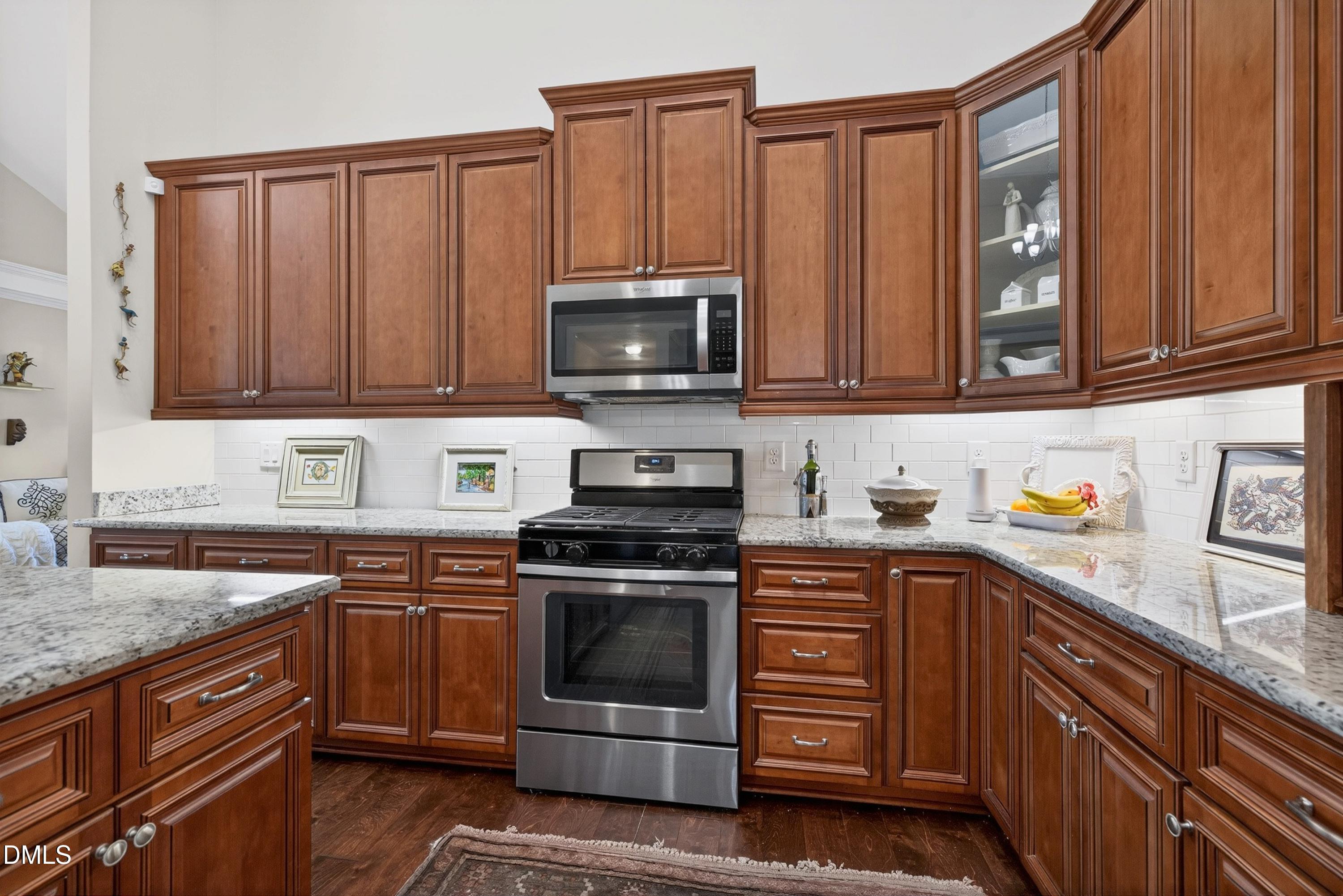 121 Telluride Trail Garner, NC 27529 - Photo 4 of 41 a kitchen with granite countertop wooden cabinets and stainless steel appliances