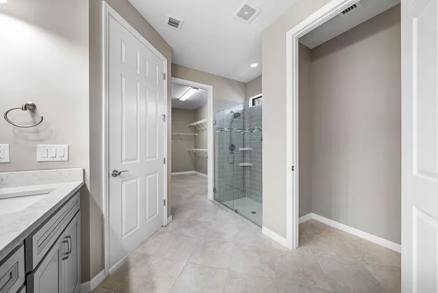 an empty room with chandelier fan and windows