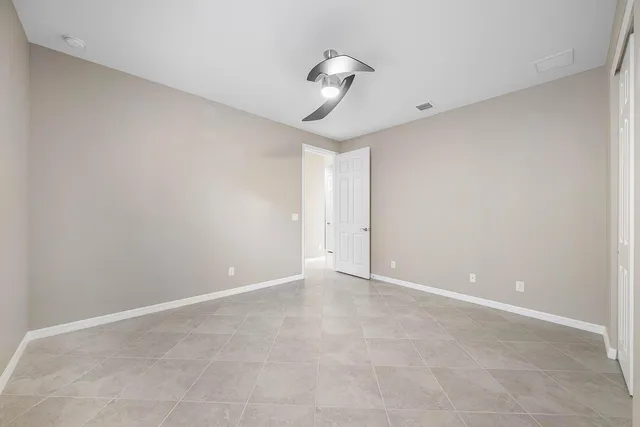 an empty room with windows and fan