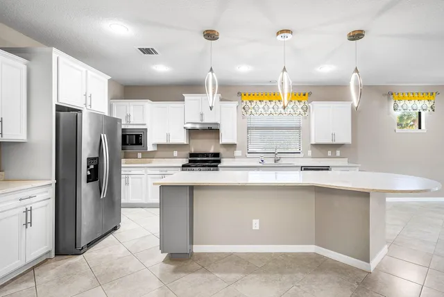 a large kitchen with cabinets and stainless steel appliances