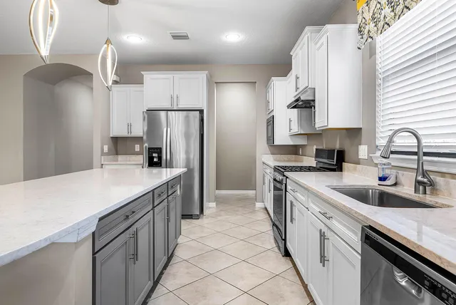 a kitchen with a stove a sink and a refrigerator
