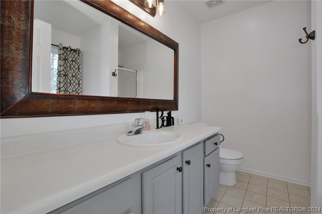 5808 Spreading Branch Road Hope Mills, NC 28348 - Photo 20 of 35 a bathroom with a sink a toilet and mirror
