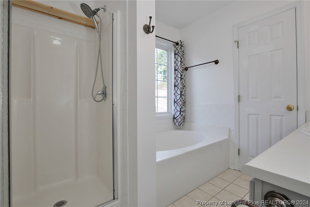 5808 Spreading Branch Road Hope Mills, NC 28348 - Photo 21 of 35 a bathroom with a bathtub and a shower