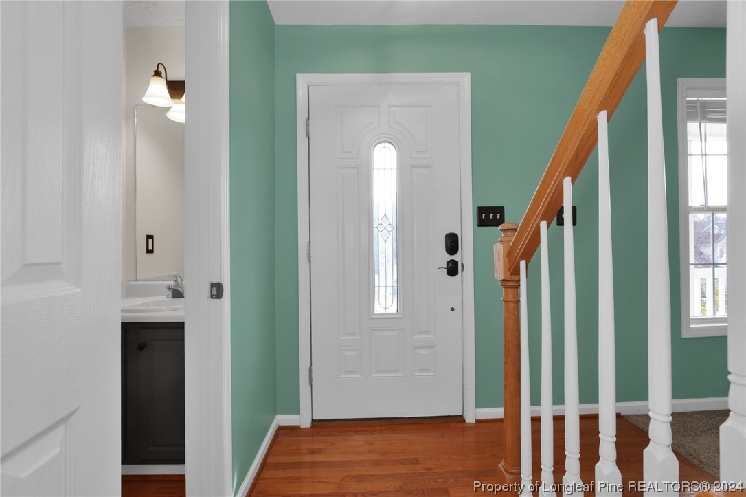 5808 Spreading Branch Road Hope Mills, NC 28348 - Photo 5 of 35 a view of a hallway with wooden floor and staircase