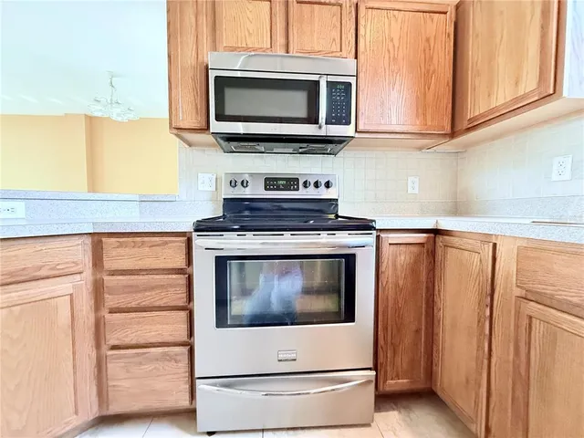 a kitchen with stainless steel appliances granite countertop a stove microwave and cabinets
