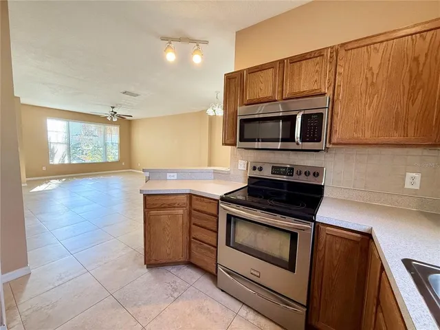 a kitchen with granite countertop a stove microwave and cabinets