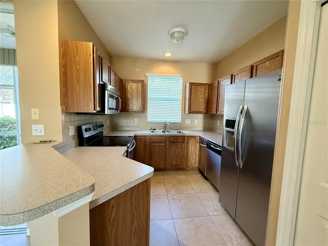 a kitchen with stainless steel appliances granite countertop a refrigerator sink and stove